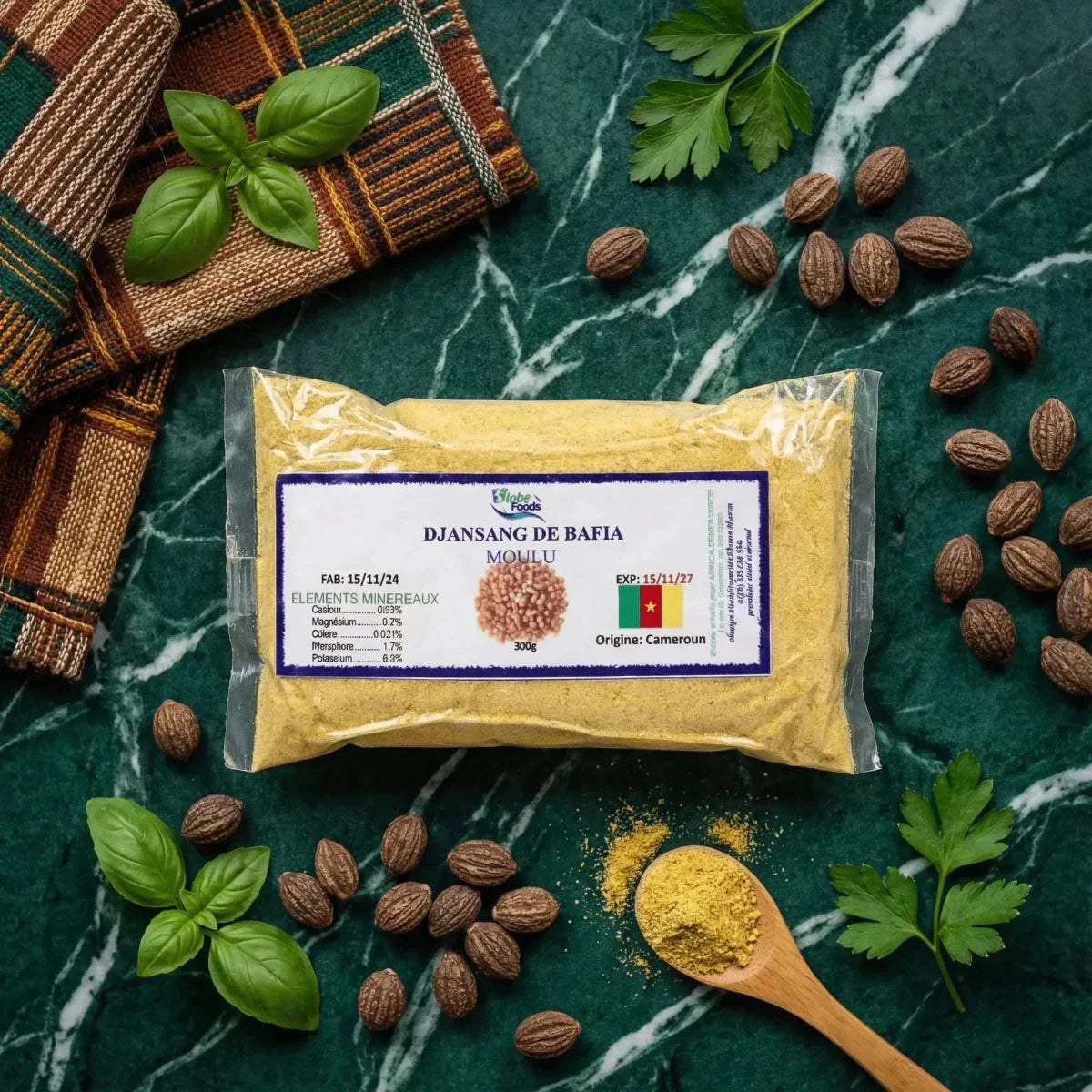 Globe Foods Beutel mit gemahlenem Djansang aus Bafia, umgeben von Djansang-Nüssen und Basilikum.