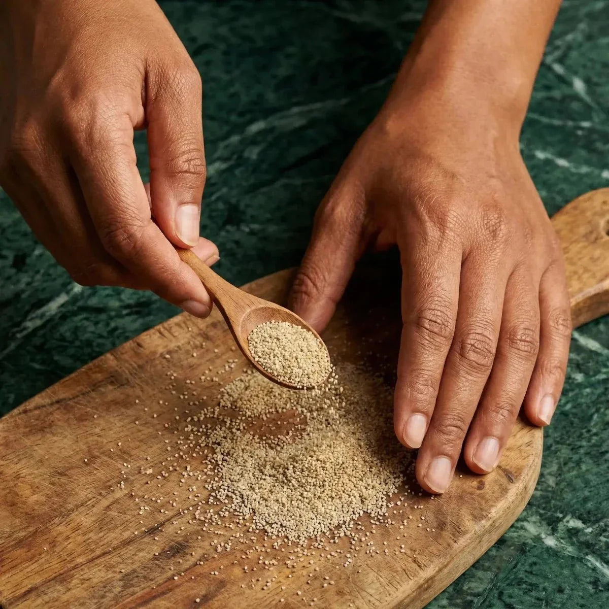 Djouka Number One. Man holding a spoonful of seeds over a cutting board.