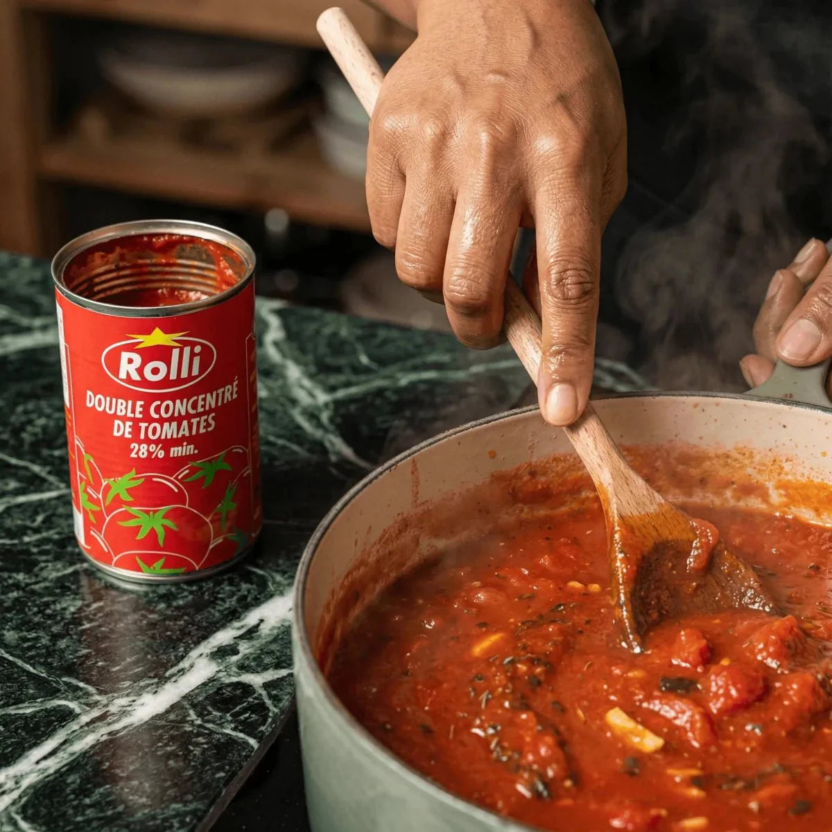 ROLII double tomato concentrate 440g, homemade. A hand stirs the sauce in a saucepan.
