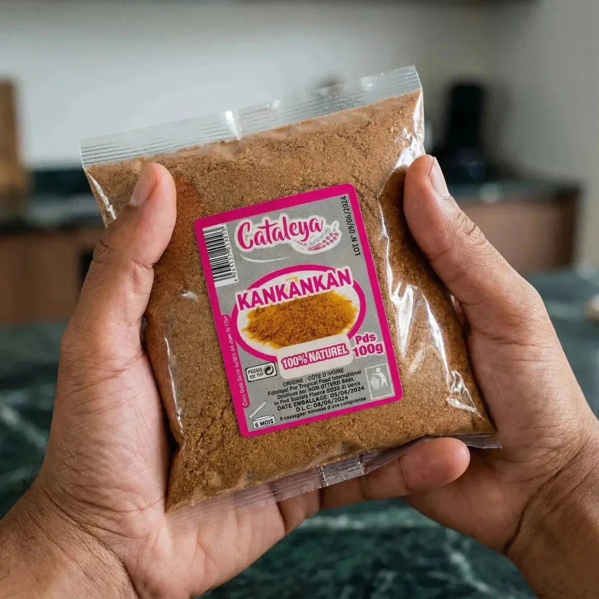 Gewürztüte Kankan CATALEYA 100g, präsentiert von zwei Händen. Die Tüte ist transparent.