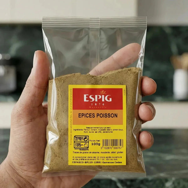 Eine durchsichtige Tüte mit ESPIG-Fischgewürzen, die in der Hand gehalten wird. Rotes und gelbes Etikett.