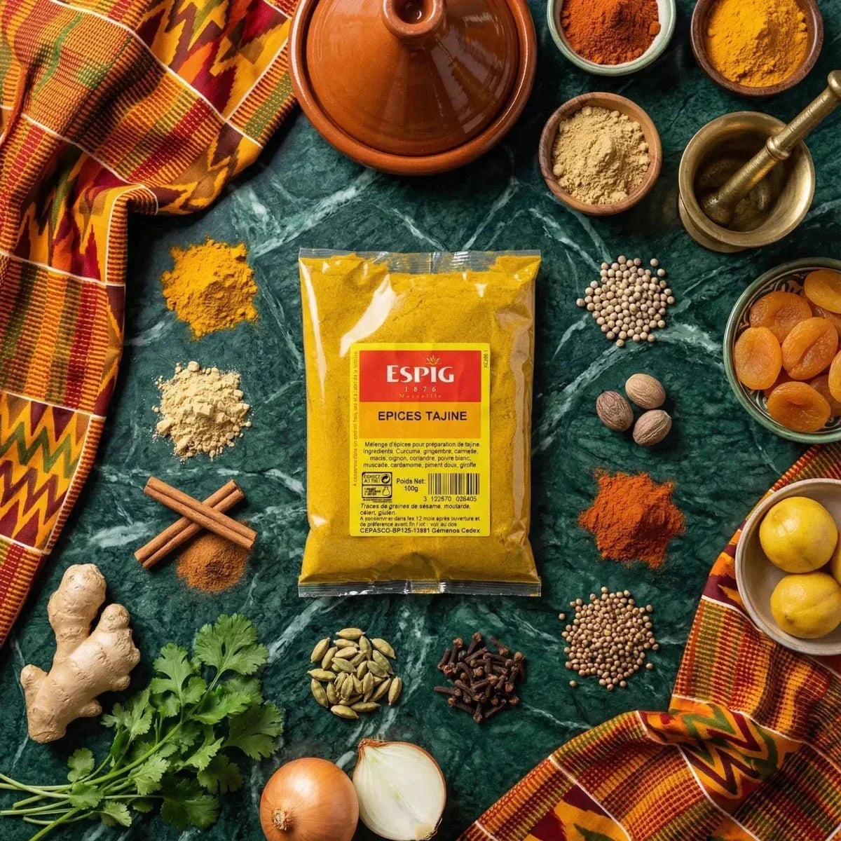 Tajine ESPIG spice sachet surrounded by fresh and dried ingredients, marbled green with a colorful fabric.