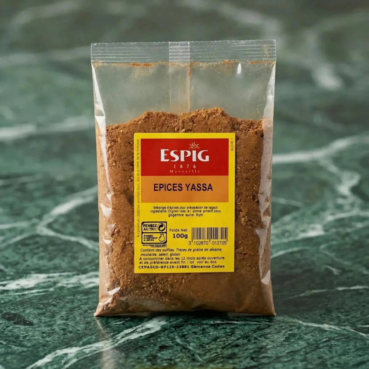 Yassa spices by ESPIG, in a transparent pouch on a marbled green background.
