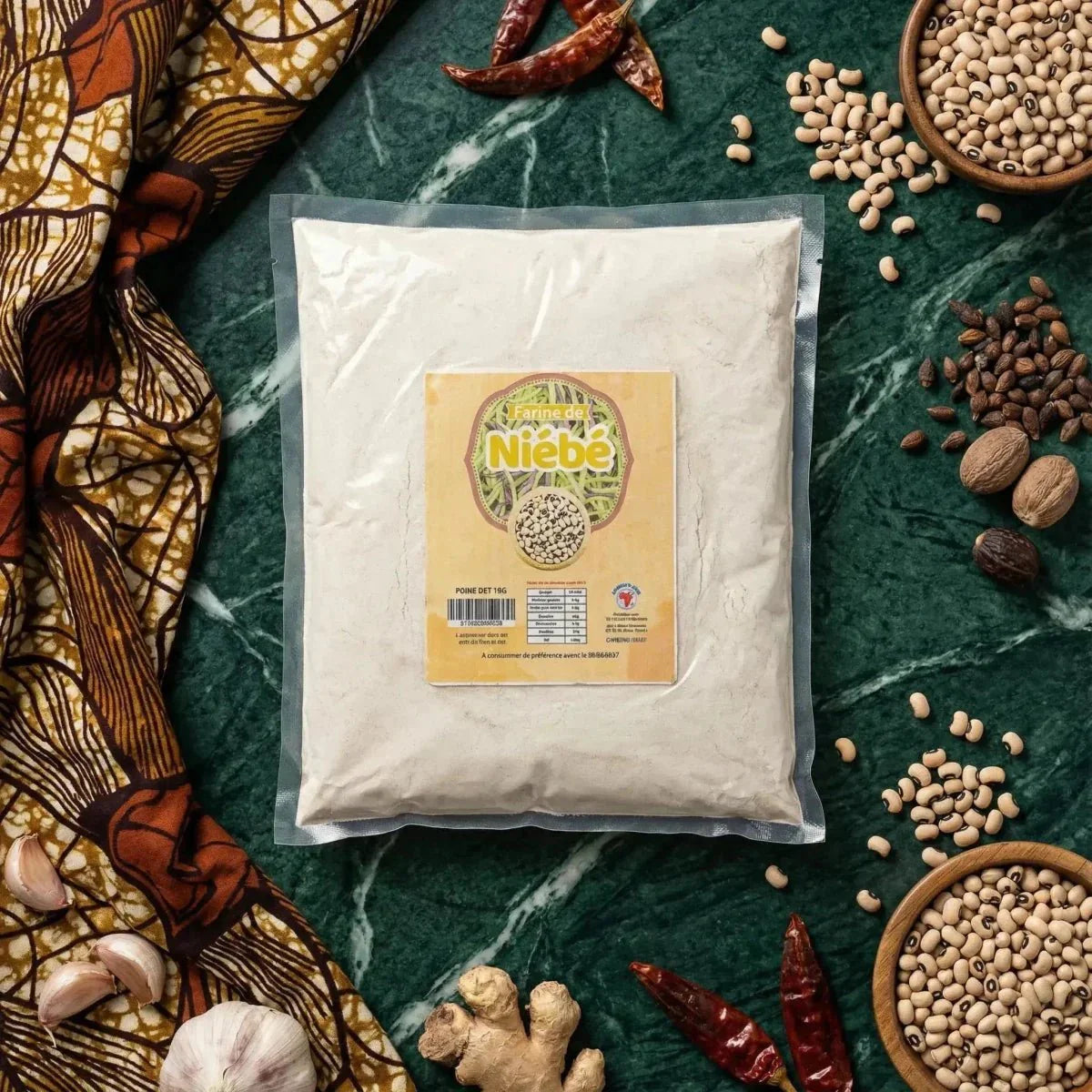 Niébé-meel NUMBER ONE in zak op gemarmerde achtergrond, met ingrediënten: peper, gember, knoflook.