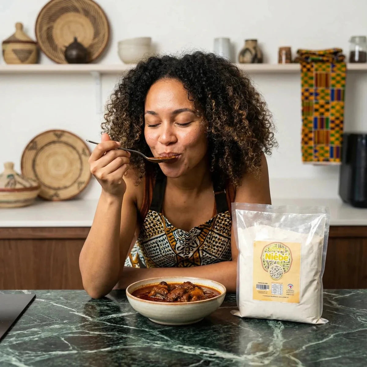 Niébé-meel NUMBER ONE. Vrouw die een gerecht proeft voor een zak meel. Kokkin.