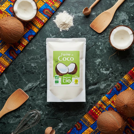 Farine de Coco Bio Sans Gluten Racines entourée de noix de coco et ustensiles de cuisine, ingrédient naturel pour recettes exotiques et saines.