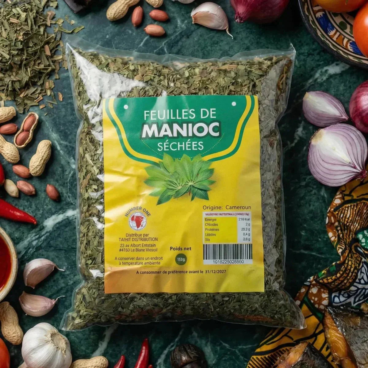 Dried cassava leaves NUMBER ONE. Bag surrounded by ingredients, marbled with a colorful fabric.