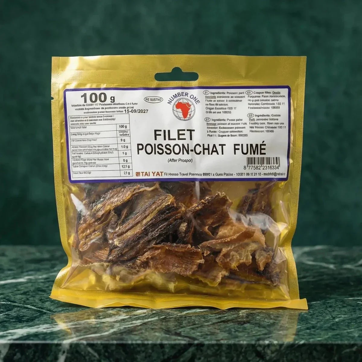 Zak gerookte meervalnetten van TAI YAT, met etiket, op een groen marmeren achtergrond.