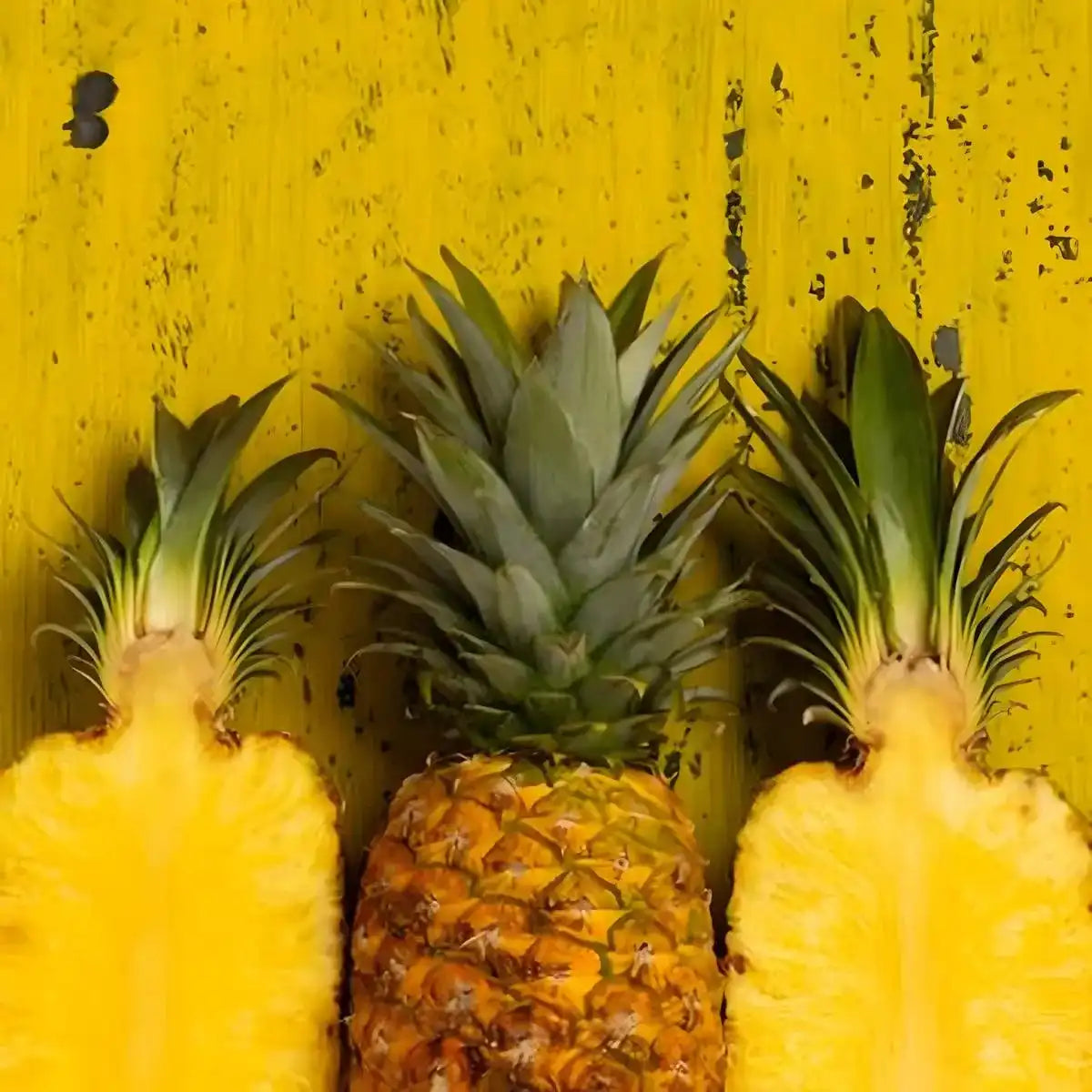 Ananas frais entier et coupé sur fond jaune, représentant l'ingrédient principal de la glace Floup ananas - Tropical à la texture légère.