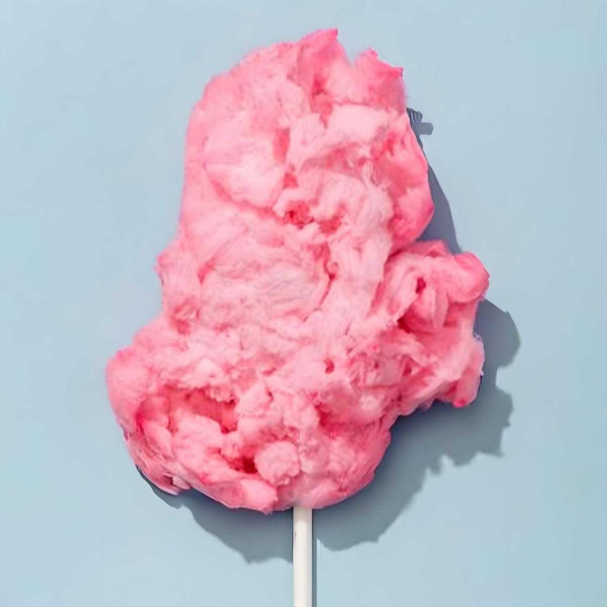 Barbe à papa rose duveteuse sur bâtonnet, texture légère et sucrée, parfaite pour les fêtes et l'épicerie sucrée NKOSI.