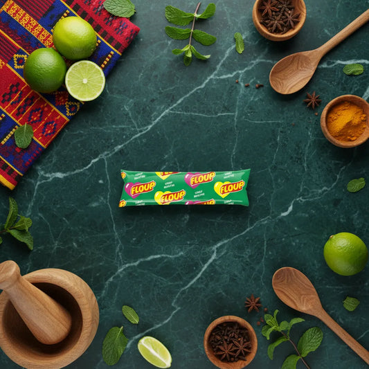 Bâtonnet Floup menthe posé sur table verte avec ingrédients frais, glace menthe rafraîchissante parfaite pour une pause sucrée estivale.