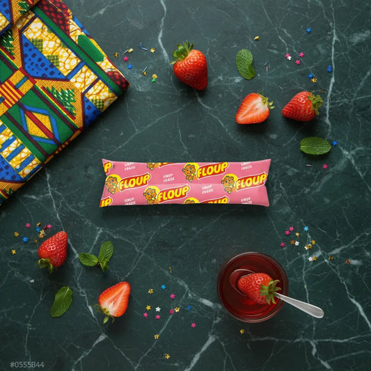 Floup fraise - Glace à l'eau fraise posée sur table en marbre avec fraises fraîches, menthe et sirop, idéale pour l'été et les pauses sucrées.