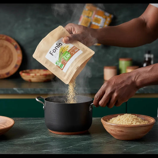 Main versant du fonio bio dans une casserole, préparation de la céréale utilisée dans les Chips de Fonio BIO IBÉMI saveur yassa.