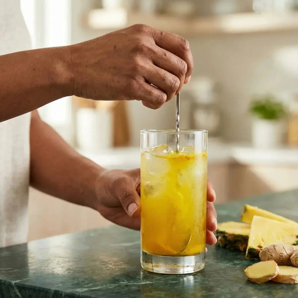 FOSTER CLARKS Jugo en polvo piña/jengibre: una persona revuelve una bebida amarilla en un vaso.