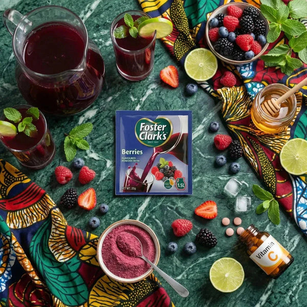 Jus en poudre Berries Foster Clark's (20g) présenté avec fruits frais, miel, et vitamine C coloré.