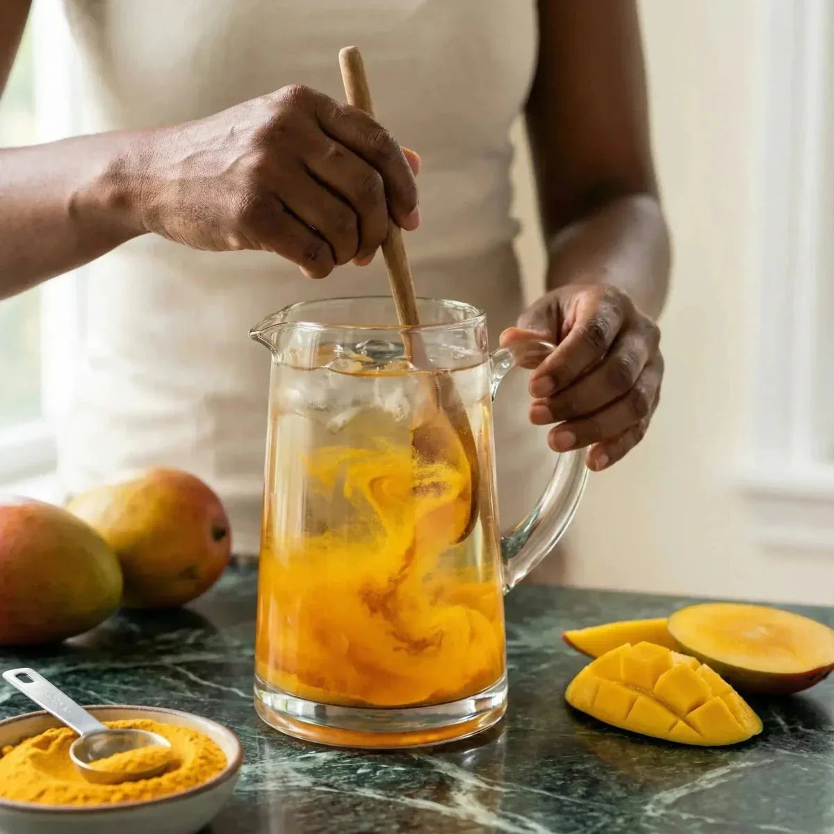 Jugo en polvo de mango FOSTER CLARKS en preparación en una jarra, con mangos frescos.