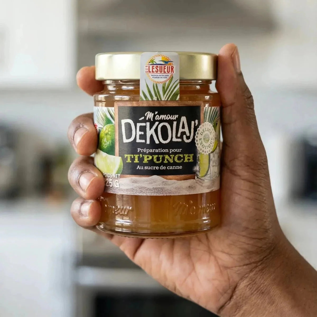 Voorbereiding voor Ti Punch met citroen van Mamour, in een doorzichtige glazen pot, vastgehouden in de hand.