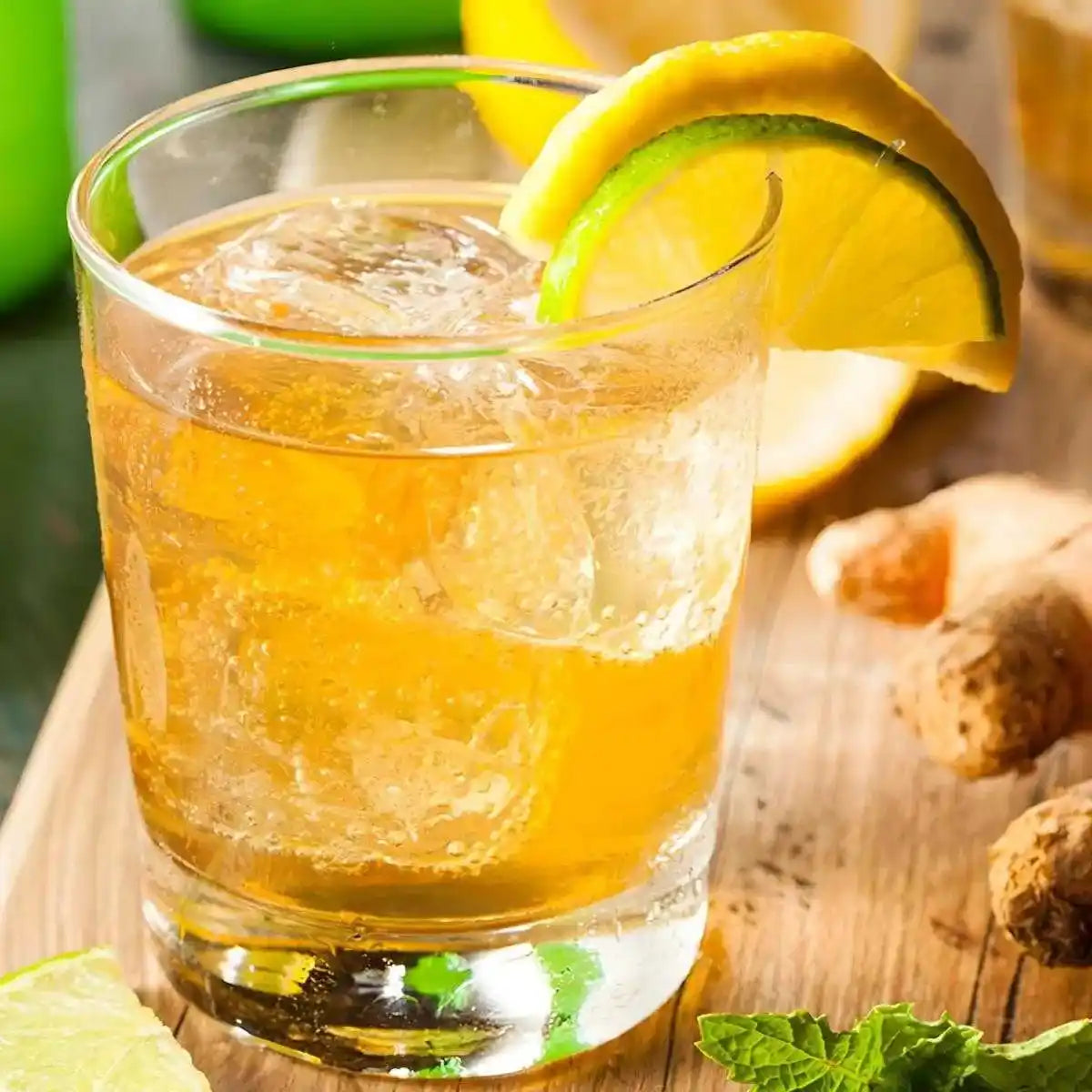 Verre de Ginger Beer OLD JAMAÏCA avec glaçons, citron et gingembre frais, soda exotique au goût intense et légèrement sucré.