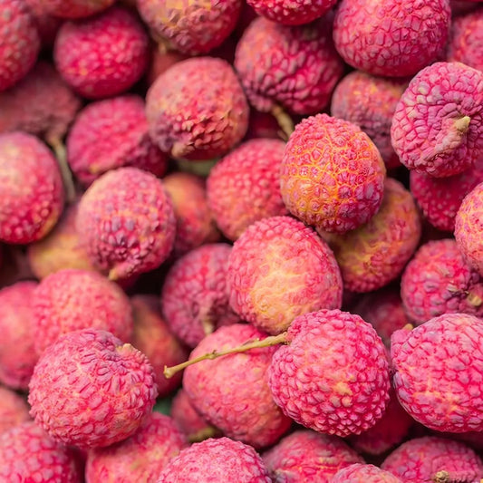 Fruits de letchi frais à la peau rose texturée, ingrédient principal des glaces letchi Paradis Glace, saveur tropicale rafraîchissante.