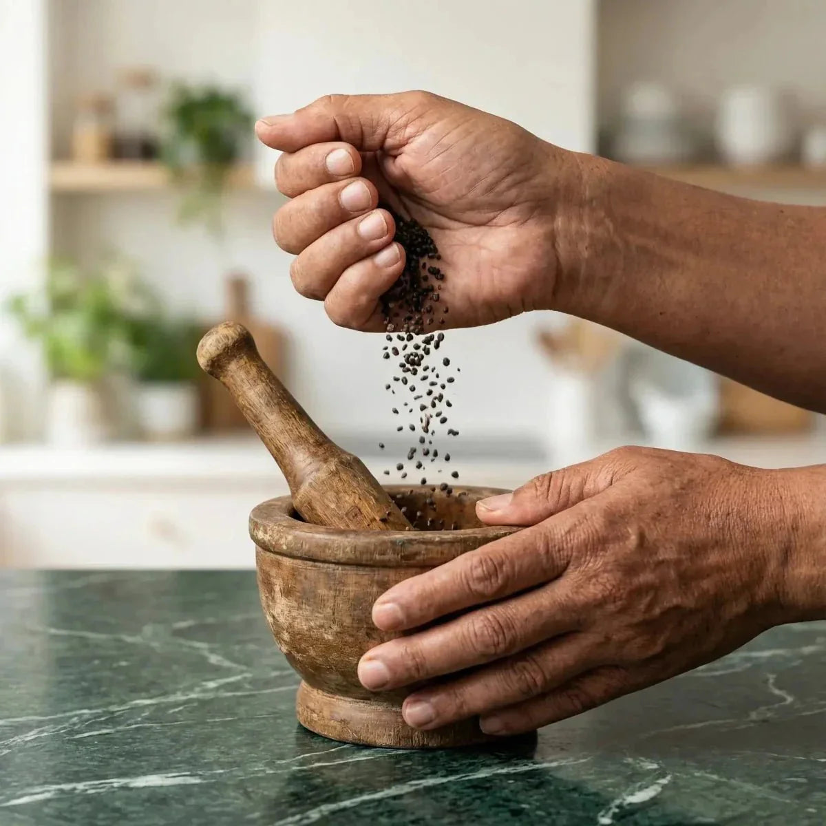 Djeka NUMBER ONE seeds: hands crumbling seeds in a wooden mortar.