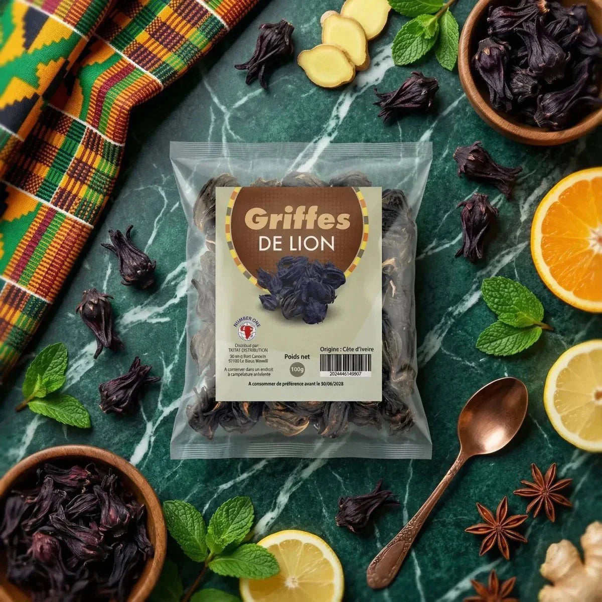 Griffes de lion NUMBER ONE (100g) sur une table en marbre avec fruits, épices, tissu africain.