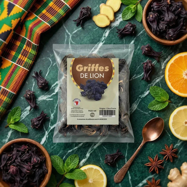 Griffes de lion NUMBER ONE (100g) sur une table en marbre avec fruits, épices, tissu africain.