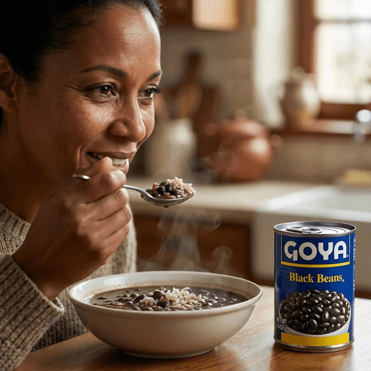 GOYA black beans, 439g. Woman enjoying a steaming bowl with a spoon and a can.