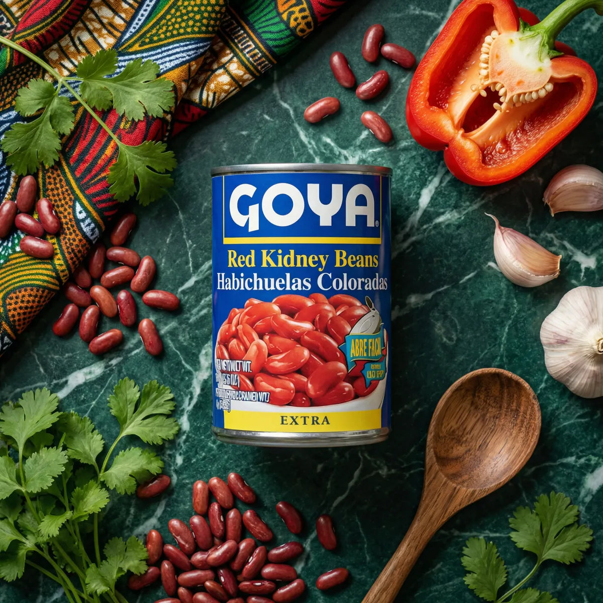 GOYA red bean can on green marble background with colorful fabric, red bell pepper, garlic.