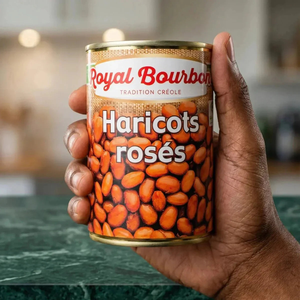 Boîte 400g Haricots Rosés ROYAL BOURBON tenue en main. Fond flou de cuisine.
