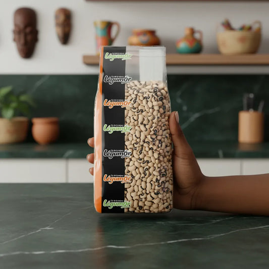 Main tenant un sachet de haricots secs Cornilles LEGUMOR, pois à œil noir de qualité, sur fond de cuisine chaleureuse et naturelle.
