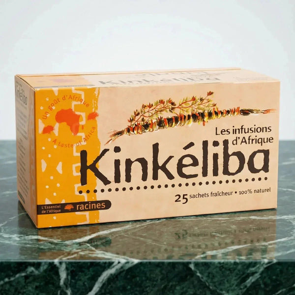 Boîte de thé Kinkéliba RACINES, saveur d'Afrique, sur une table en marbre vert. Publicité.