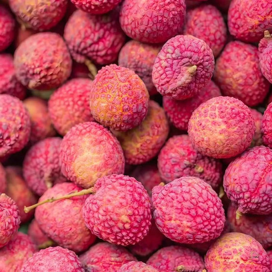 Litchis frais à la peau rose texturée, fruit exotique utilisé dans le jus d'aloe vera et litchi GRACE, boisson douce et rafraîchissante.