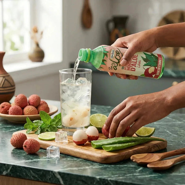 Aloe-Vera- und Litschi-Saft GRACE. Das Getränk wird in ein Glas mit Eiswürfeln gegossen.