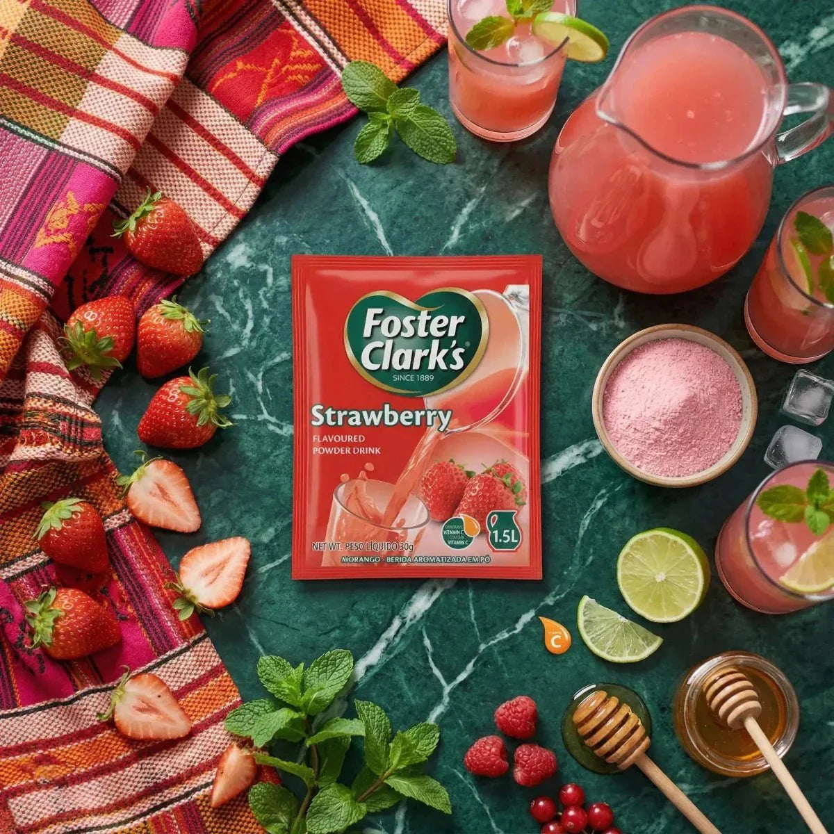 Immagine FOSTER CLARKS: polvere per bevanda al gusto Fragola. Tovaglia colorata, fragole fresche.