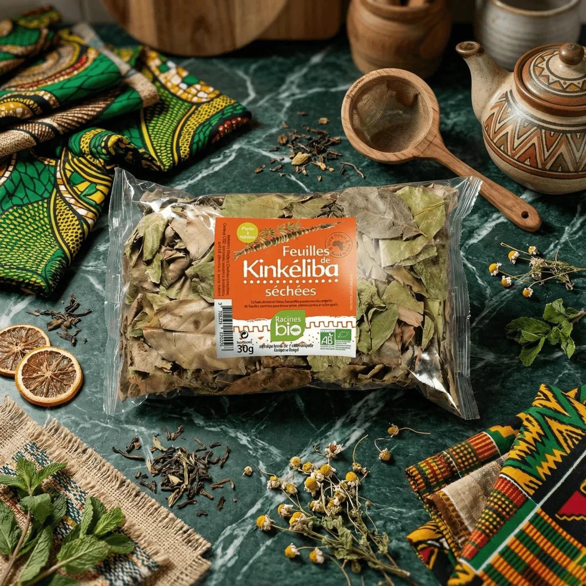 Organic Kinkeliba Root 32g sachet surrounded by dried leaves and mint.