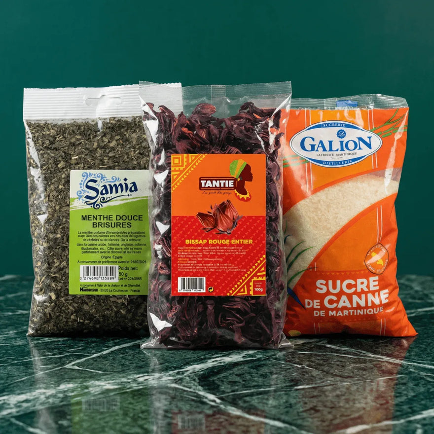 Trois paquets sur une table : menthe Samia, Bissap rouge Tantie, et sucre Galion de Martinique.