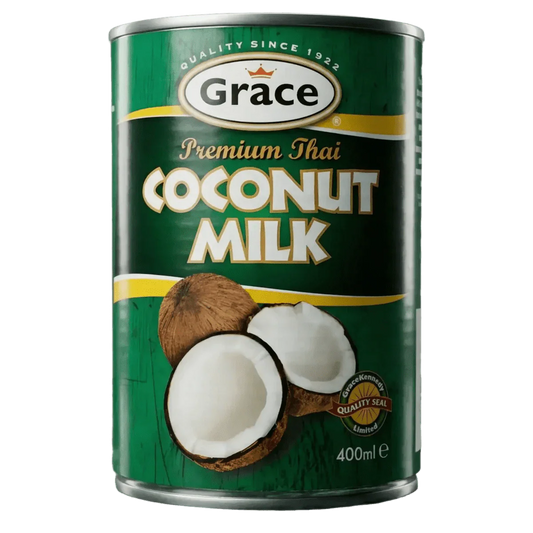 Canette de lait de coco Grace de 400mL devant un fond vert ; des moitiés de noix de coco.