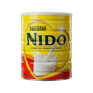 Nestlé NIDO Milchpulverdose. Produktfoto mit einem Glas Milch.