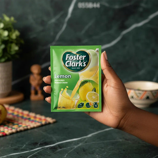 Sachet de jus en poudre citron FOSTER CLARKS tenu en main, format pratique pour une boisson citronnée rapide et désaltérante.