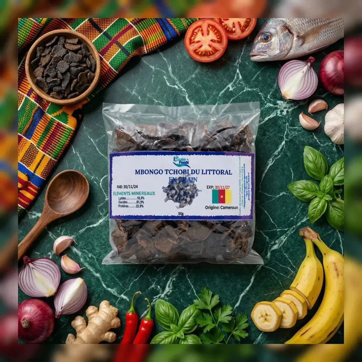 Un sachet de Mbongo Tchobi du Littoral de Gcube Foods entouré d'ingrédients : poisson, banane.