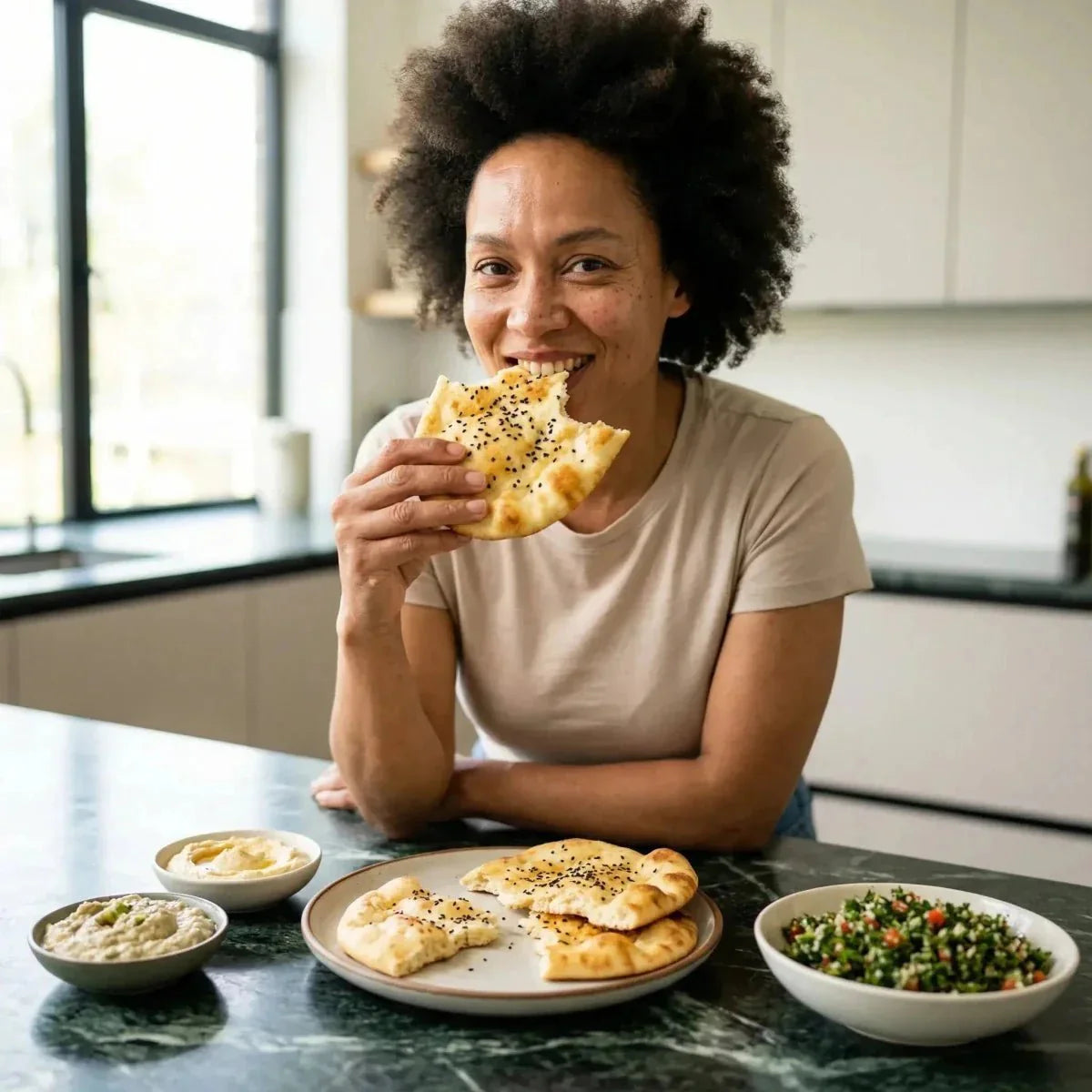 Una donna gusta del pane ai semi di nigella SAMIA, con tabulè e hummus.