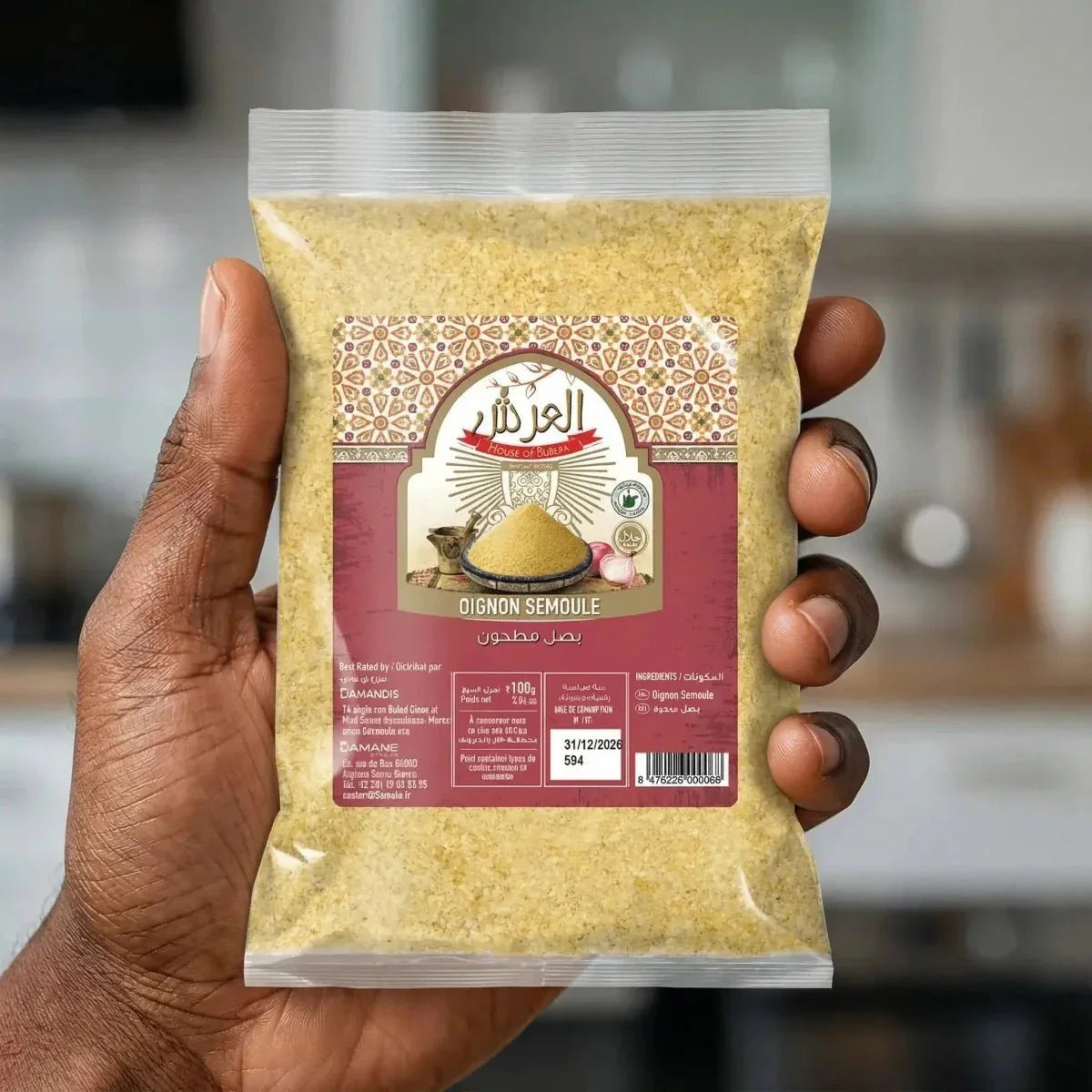 Beutel mit Zwiebelsemolina „House of Rubera“, der von einer Hand vor einem Küchenhintergrund gehalten wird.