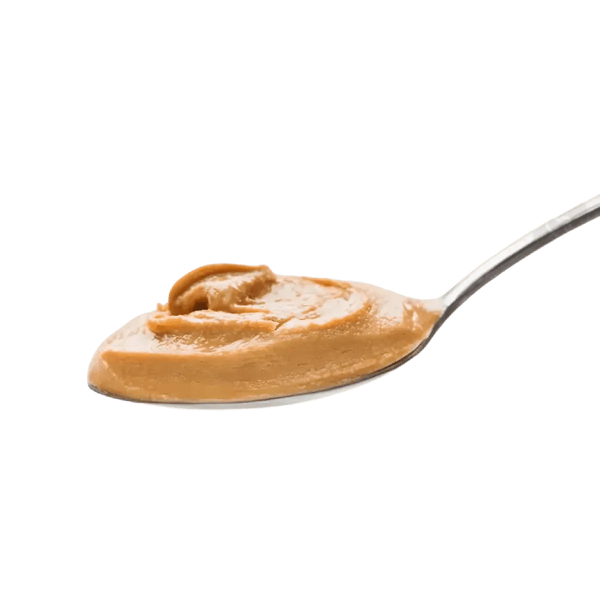 Pâte d'arachide crémeuse par DAKATINE, présentée sur une cuillère en métal argenté.