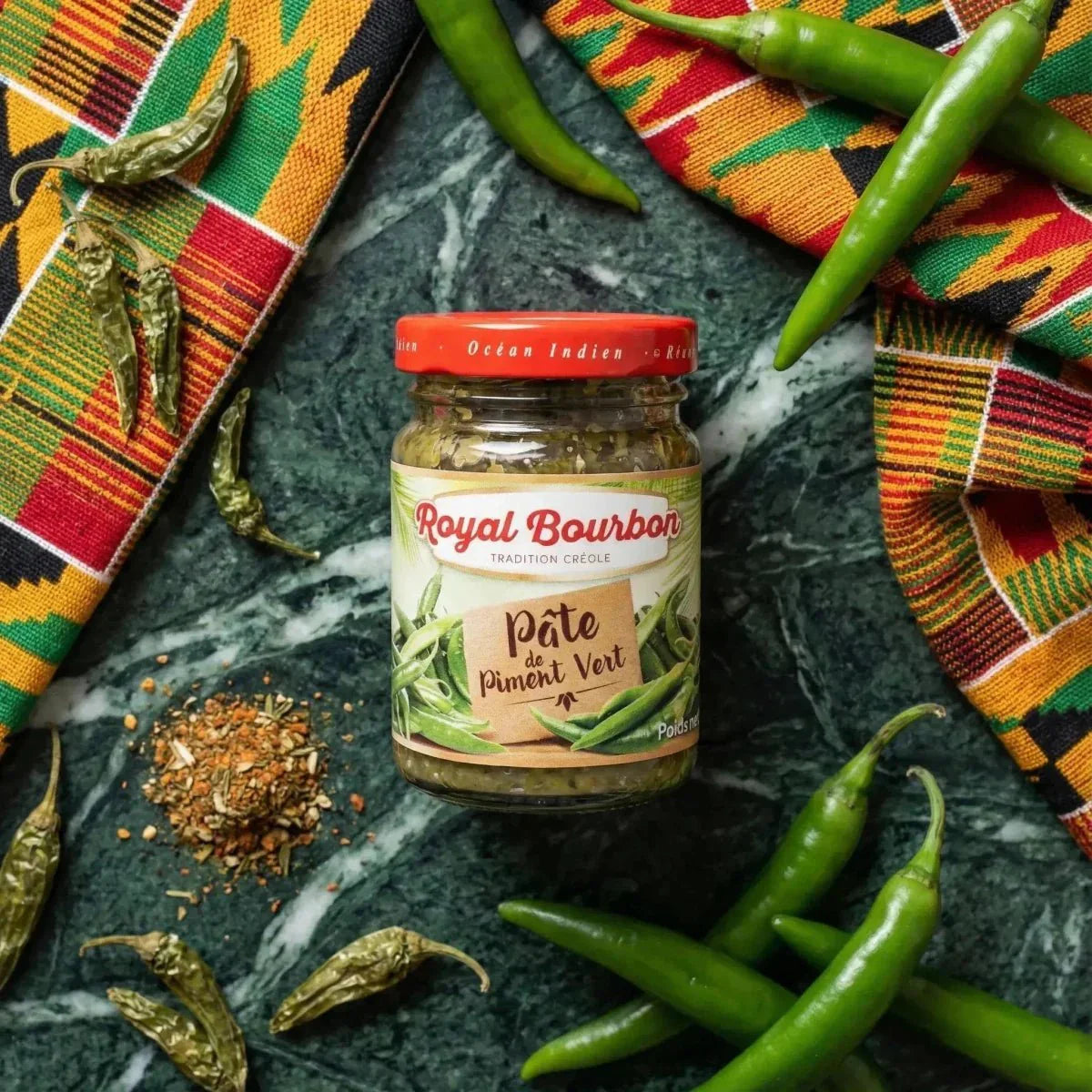 Pâte de piment vert ROYAL BOURBON. Pot sur fond marbré, entouré de piments verts frais.