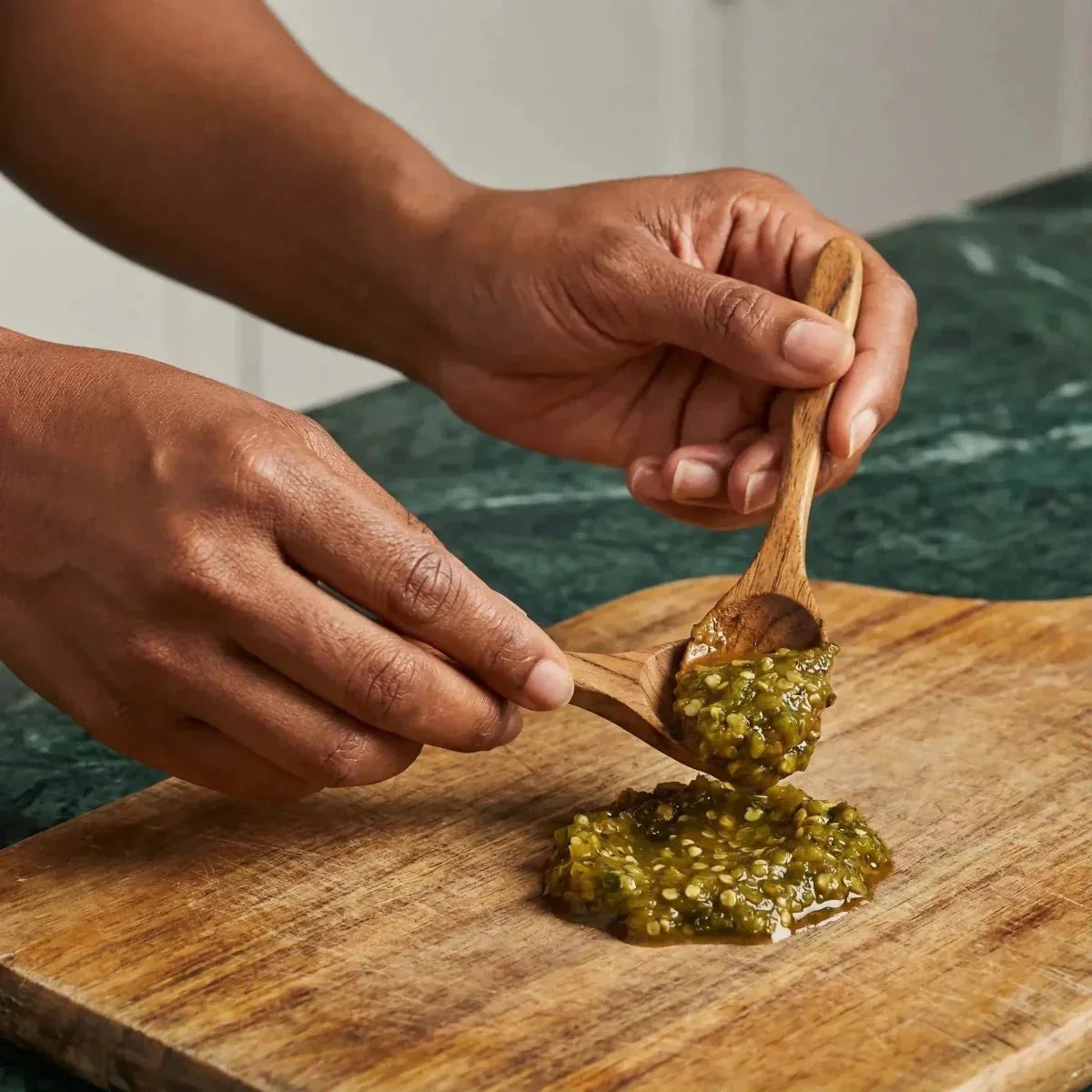 Pâte de piment vert ROYAL BOURBON. Deux cuillères en bois, une sur une planche.