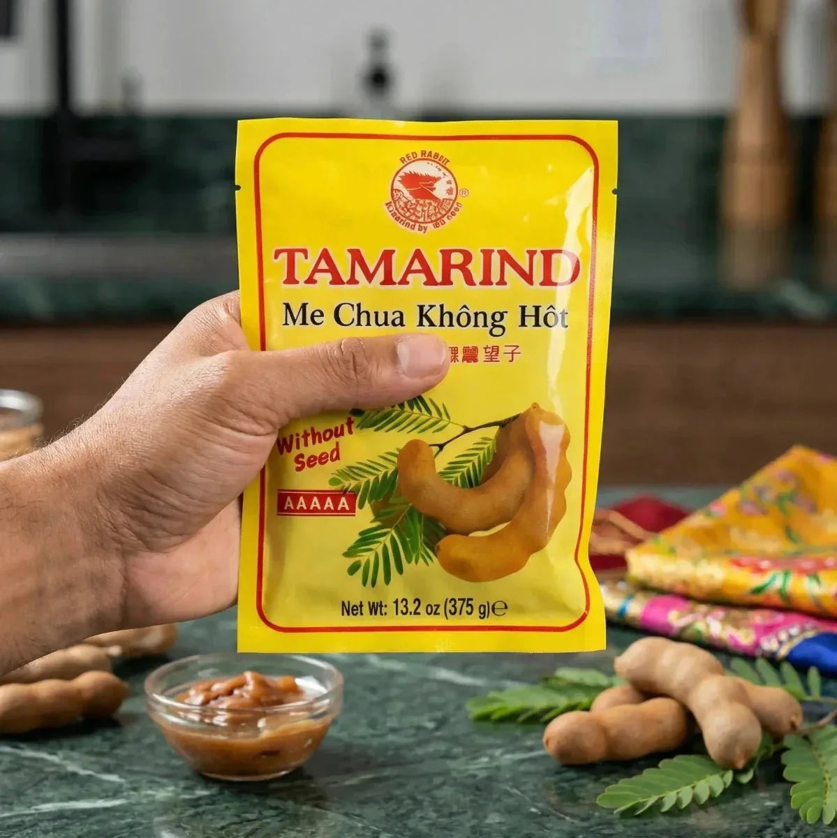 Pasta di tamarindo RED DRAGON senza semi, 375g, tenuta in mano, con tamarindo fresco, pasta in ciotola.