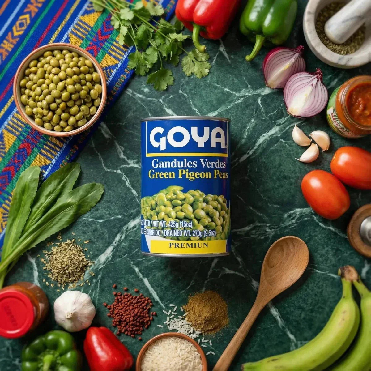 GOYA grüne Kichererbsen in Dosen, umgeben von frischen Zutaten auf marmoriertem grünem Hintergrund.