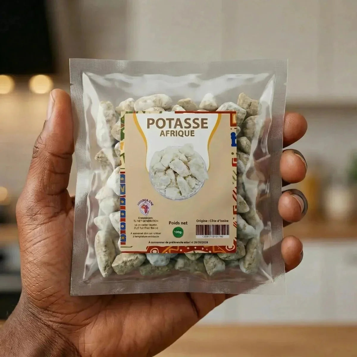 Potasse Afrique von NUMBER ONE, in einer transparenten Verpackung, in der Hand.