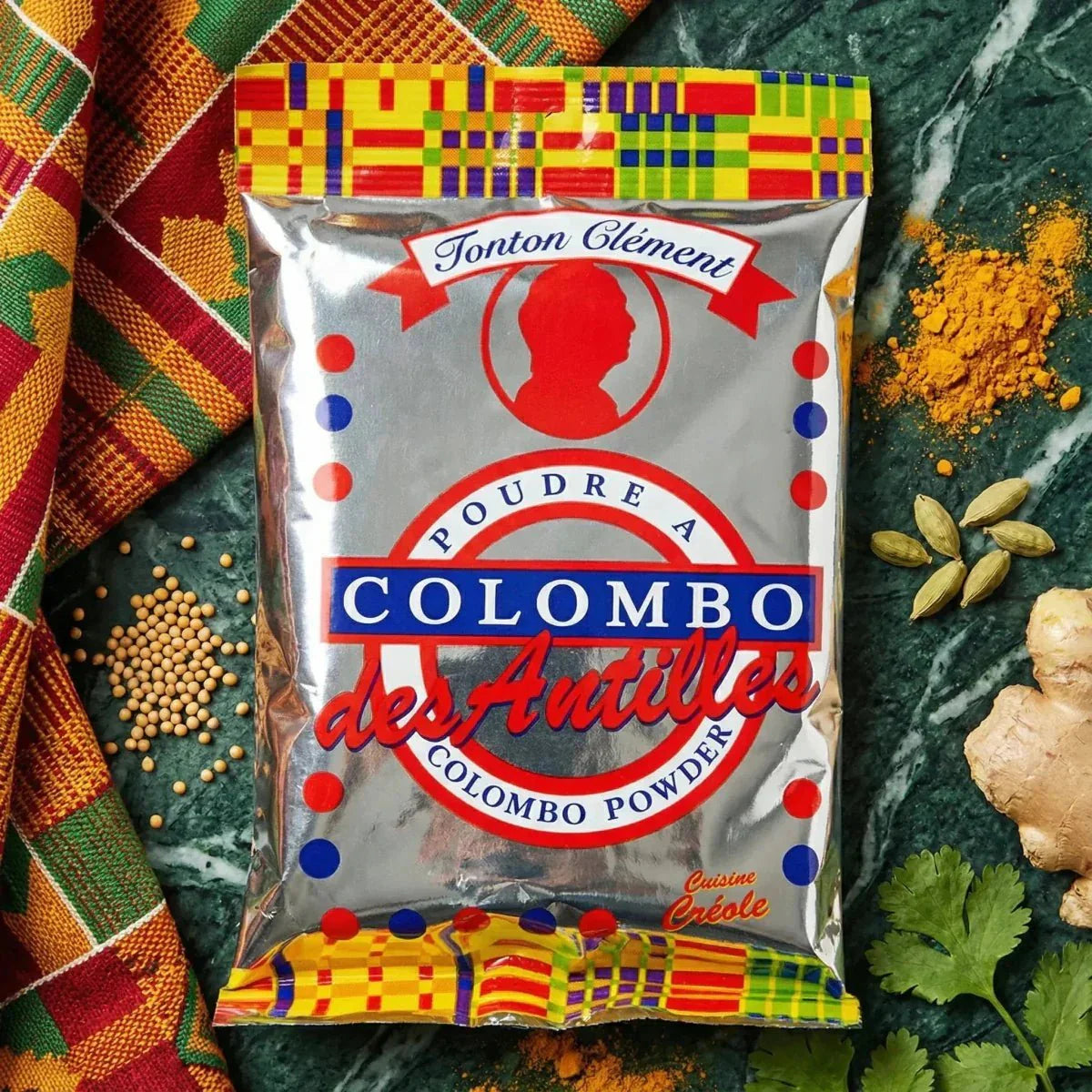 Polvo de colombo de Tonton Clément, en una bolsa plateada decorada con colores vivos.