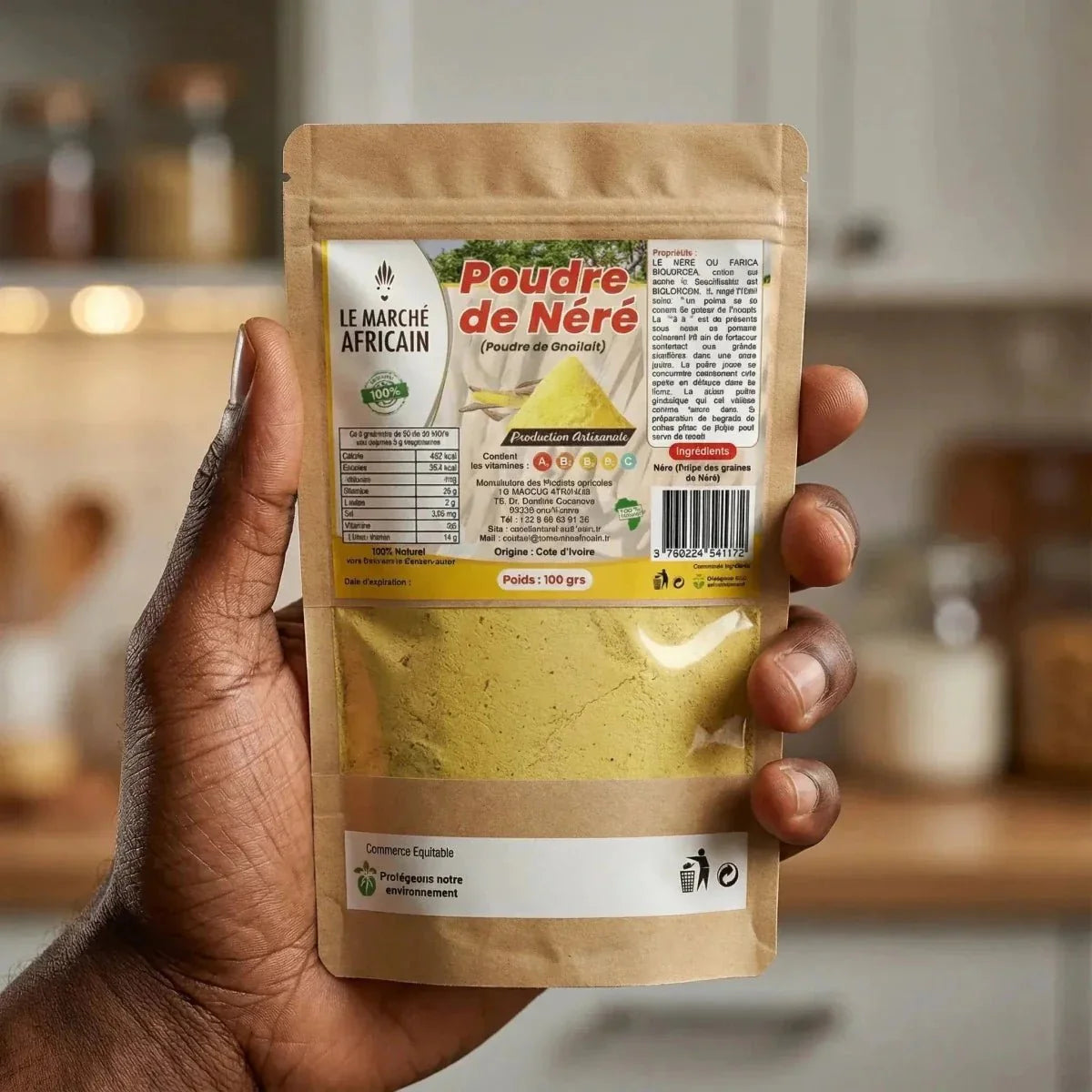 Poudre de Néré par Le Marché Africain, dans un sachet kraft tenu dans une main.
